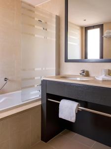 La salle de bains est pourvue d'un lavabo, d'une baignoire et d'un miroir. dans l'établissement New Hotel of Marseille - Vieux Port, à Marseille