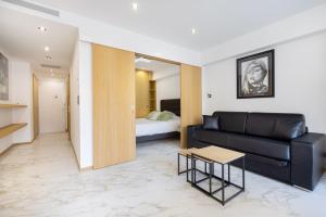 un soggiorno con divano nero e letto di Agence des Résidences - Appartements privés du 45 CROISETTE - Standard a Cannes