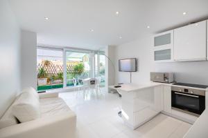 - un salon blanc avec un canapé et une table dans l'établissement Agence des Résidences - Appartements privés du 45 CROISETTE - Standard, à Cannes