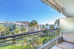 uma varanda com um sofá e vista para o oceano em Agence des Résidences - Appartements privés du 45 CROISETTE - Standard em Cannes