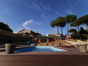 a swimming pool with some orange umbrellas and trees at Corte Signoretti - Hystorical Villa in Canale Monterano