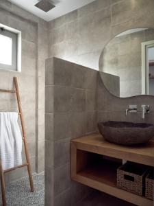 bagno con lavandino e specchio di Cassiopeia Rooms & Suites a Laganas