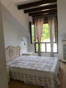 a bedroom with a bed and a large window at El Nial de L'Andolina in Cangas de Onís