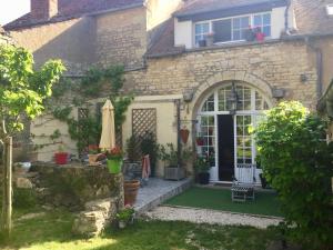 a stone house with a green lawn in front of it at La Treille Muscate in Tannay