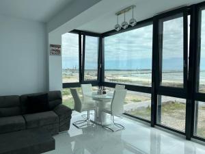 a living room with a table and chairs and a couch at Luxury apartment with sea view in Mamaia Sat/Năvodari