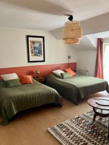 1 dormitorio con 2 camas y mesa en La Treille Muscate, en Tannay