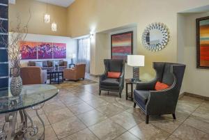 uma sala de estar com cadeiras e uma mesa em La Quinta by Wyndham Tucson - Reid Park em Tucson