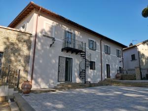 a white building with stairs in front of it at Corte Signoretti - Hystorical Villa in Canale Monterano