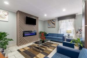 a living room with blue couches and a fireplace at Quality Inn Cleveland in Cleveland