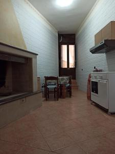 a kitchen with a stove and a table with chairs at Meraviglie Salentine in Lequile