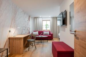 a living room with a red couch and a table at Gasthof Krone in Kinding