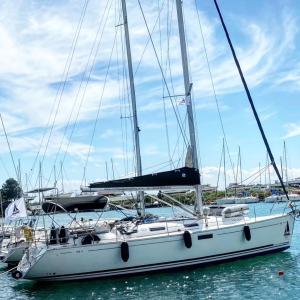 a white sailboat sitting in the water in a harbor at Godspeed in Thessaloniki