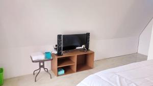 1 dormitorio con 1 cama y mesa con TV en Joglo Kumpul Resort, en Cangkiran