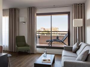 a living room with a couch and a large window at New Hotel of Marseille - Vieux Port in Marseille