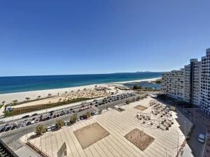 uma vista para uma praia com cadeiras e um edifício em ALBATROS 12-B estudio con vista mar em Empuriabrava