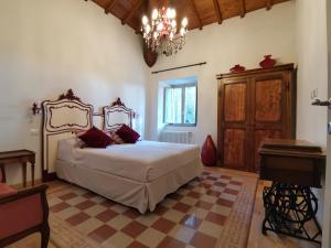 a bedroom with a large bed and a chandelier at Corte Signoretti - Hystorical Villa in Canale Monterano +49 photos