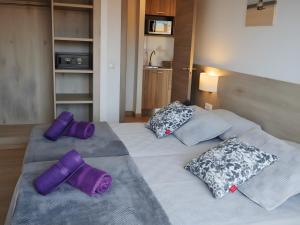 1 dormitorio con 2 camas con almohadas moradas en Marina Beach Apartaments, en Lloret de Mar