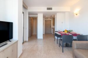 - une salle à manger et un salon avec une table et des chaises dans l'établissement Marina Beach Apartaments, à Lloret de Mar