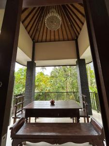 a porch with a wooden table and a window at Pondok Damai Sidemen in Sidemen