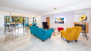 a living room with two blue chairs and a table at Stylish villa near Dubrovnik with a swimming pool in Mlini