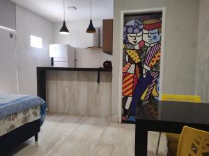 une porte menant à une cuisine avec un tableau sur le mur dans l'établissement Maravilhoso loft beira mar, à Japaratinga 26 autres photos