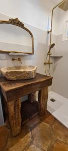 a bathroom with a stone sink and a mirror at L'Elementariu in Nonza