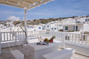 a balcony with a table and a view of a city at Myconian Princess in Mýkonos City