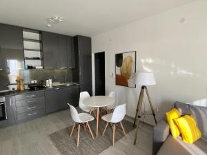 a kitchen with a table and chairs and a couch at Infinity Panorama Apartment in Tivat