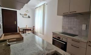 cocina con encimera y mesa en L'Elementariu en Nonza