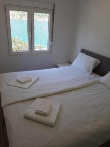 ein Schlafzimmer mit 2 Betten und Handtüchern darauf in der Unterkunft Luxury flat with amazing view INES in Kotor