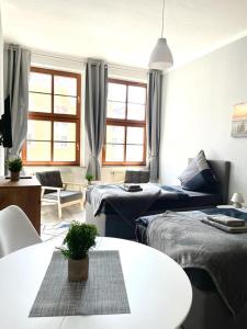 a living room with two beds and a table at City Apartments Erfurt in Erfurt