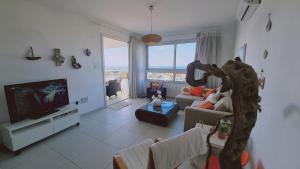 a living room with a couch and a tv at STAY Kapparis View Apartment in Paralimni