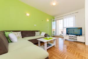 ein Wohnzimmer mit einem Sofa und einem TV in der Unterkunft Apartment Mali in Trogir