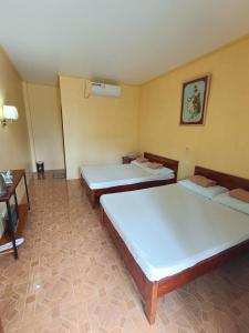 een kamer met 2 bedden en een bureau bij CocoVille Guesthouse in Alegria