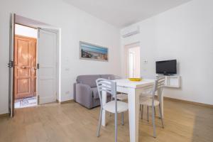 ein Wohnzimmer mit einem Tisch, Stühlen und einem Sofa in der Unterkunft Casa Vacanza Messina in Messina