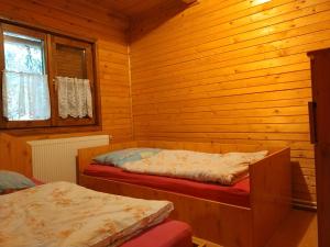 a bedroom with two beds in a wooden cabin at Cabana DUY-KAY in Lacu Rosu