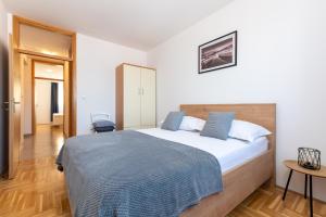 1 dormitorio con 1 cama grande con manta azul en Apartment Mali, en Trogir
