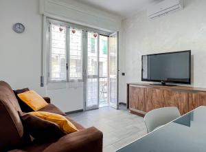 un soggiorno con divano e TV a schermo piatto di NUOVO BILOCALE VISTA MARE a Savona