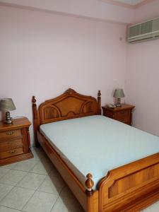 1 dormitorio con 1 cama de madera y 2 mesitas de noche en Porcelanico Villa, 