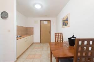 cocina y comedor con mesa de madera y sillas en Hotel Rooms Roccia, en Novigrad (Dalmacia)