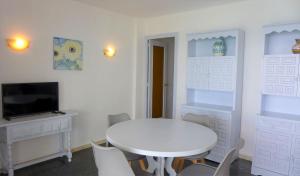 a white dining room with a white table and chairs at Apartamentos Nautilus in Salou
