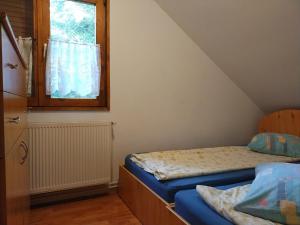 a small room with two beds and a window at Cabana DUY-KAY in Lacu Rosu