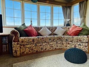 a couch with pillows on it in a living room at 157 Amour Caravan in Tywyn