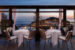 una sala da pranzo con tavoli e sedie su un balcone di Hotel Vis à Vis a Sestri Levante