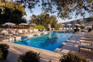 una piscina con sedie a sdraio e ombrelloni di Hotel Vis à Vis a Sestri Levante