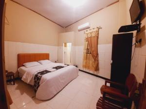 a bedroom with a bed and a television in it at Hotel Meurah Mulia Syariah in Banda Aceh