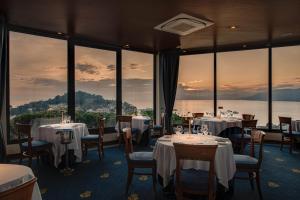 - un restaurant avec des tables, des chaises et de grandes fenêtres dans l'établissement Hotel Vis à Vis, à Sestri Levante