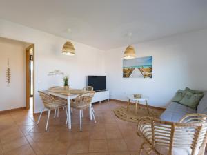 ein Wohnzimmer mit einem Tisch und einem Sofa in der Unterkunft Private Terrace Majanicho Home -Garden & Pool in La Oliva