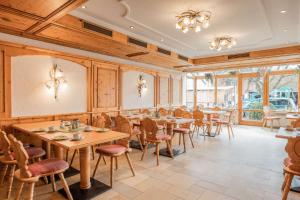 a restaurant with wooden walls and tables and chairs at Gasthof Krone in Kinding
