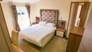 a small bedroom with a bed and a window at Luxury 3 Bed 2 Bath Lodge with Sea Views! in Exmouth